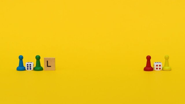 Inscription "let's play" on wooden blocks gradually appears on yellow background next to multi colored chips for the game: blue, yellow, green and red near two dice
