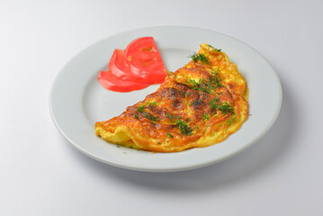Scrambled eggs with fresh herbs and tomates on a white background. Delicious breakfast concept.