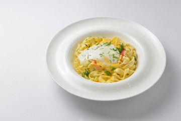Delicious vegetarian dish of pasta with cheese served in a white plate over white background.