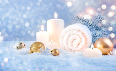 Christmas decoration and burning candles in snow, holiday spa concept