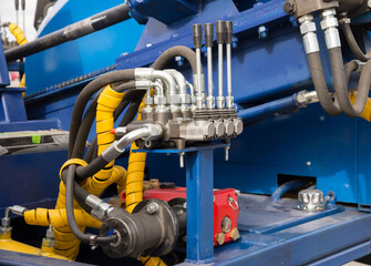 Hydraulic tubes, fittings and levers on control panel, close up of pipe system