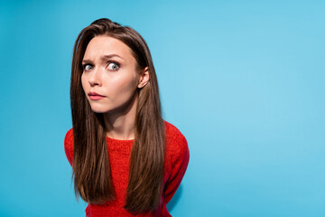Photo of suspicious lady look distrustful on camera wear red knitted sweater isolated blue color...