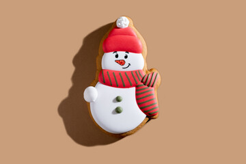 Christmas decorated cookies. Festive pastry. New Year tradition. Winter holiday culinary. Happy gingerbread snowman biscuit figure colorful icing isolated on beige background.