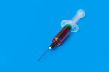 Medical syringe on blue