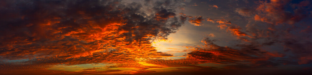 Fototapeta premium Panorama Sunset with clouds, in orange and colorful shades,World Environment Day concept: Fiery orange sunset sky with dark clouds.