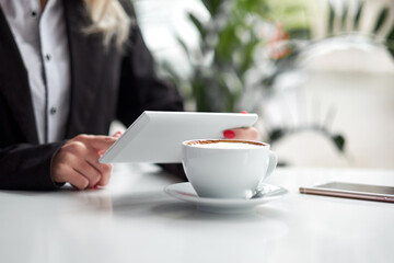 Business woman hands using smart phone and cup of coffee.