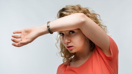 Portrait of frightened young woman covering her eyes with hands. Human emotions, facial expression concept