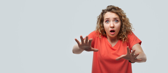 Image of young shocked woman expressing surprise on camera. Human emotions, facial expression concept. Copy space