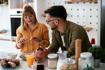Young couple making sandwich at home. Loving couple enjoying in the kitchen...