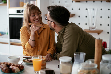 Young couple making sandwich at home. Loving couple enjoying in the kitchen...