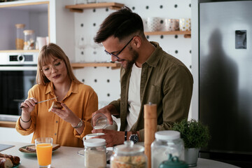 Young couple making sandwich at home. Loving couple enjoying in the kitchen...