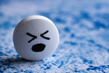 Big white cute Pill with drawn face smile on color background. the concept of antidepressants