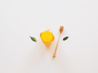 Top view healthy honey with dipper and leaves isolated on white