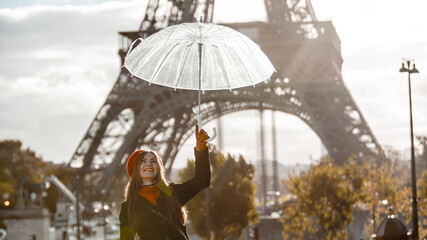 Beautiful woman with umbrella in parisian street happy smiling, motion
