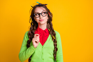 Photo of minded geek girl look empty space think wear green shirt isolated on bright yellow color background
