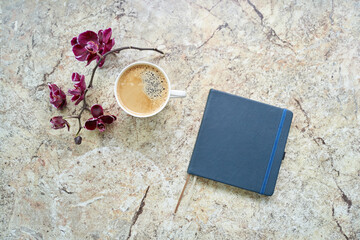 Fototapeta na wymiar Cup of black coffee with orchid, paper notepad flat lay on marble table flat lay. High quality photo