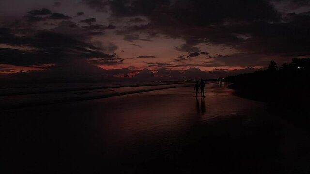 Beautiful cinematic footage of the Silhouette of a father and his son in a magic sunset in the beach of Costa Rica