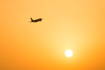 Fototapeta na wymiar 上昇する旅客機と夕日