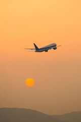Fototapeta na wymiar 上昇する旅客機と夕日