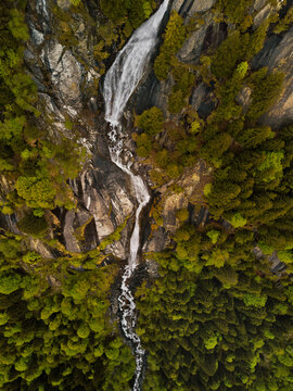 Aerial view of a majestic waterfall in Val di Mello, Lombardy, Italy.
