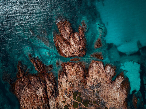 Aerial view of a reddish remote cliff near Isola Rossa, Sardinia, Italy.