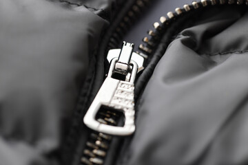 Black jacket has metal zip fastened. Repair of clothes and accessories concept