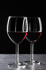 Fototapeta na wymiar two red wine glasses on a slate board with copy space for your text