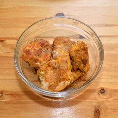 Ready-made breaded chicken fillet on plate on wooden background.