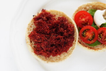 corned beef and cherry tomato in English muffin sandwich