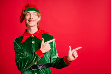 Photo of funny elf guy point finger empty space x-mas christmas jolly adverts isolated over shine...