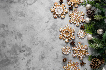 Fototapeta na wymiar Gingerbread cookies, snowflakes shaped with icing, fir branch. Abstract Christmas food, cookies. Copy space.