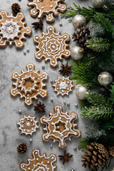 Gingerbread cookies, snowflakes shaped with icing, fir branch. Abstract Christmas food, cookies. Top view.
