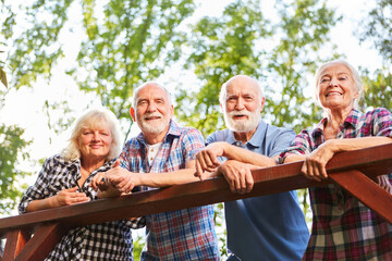 Seniors as friends lean on bridge railings
