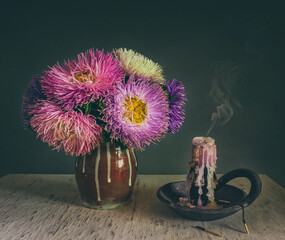 Still life with a bouquet of asters and extinguished candles. Vintage.
