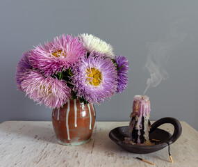 Still life with a bouquet of asters and extinguished candles. Vintage.