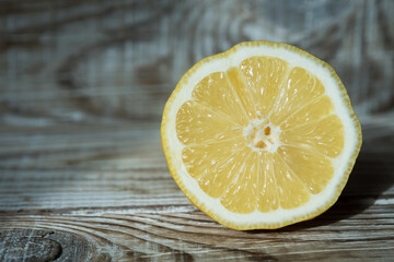 cut half of a lemon on a wooden background
