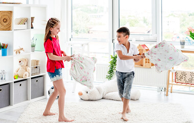 Laughing kids having fun while pillow fight