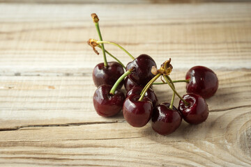 dark berries of ripe cherries on a wooden background
