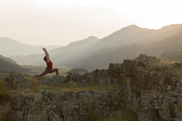 silhouette of senior woman doing yoga in mountains. sunset summer time