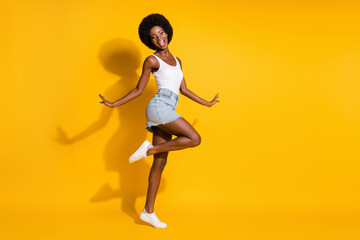 Fototapeta na wymiar Full length body size view of pretty cheerful wavy-haired lady jumping dancing having fun isolated over bright yellow color background