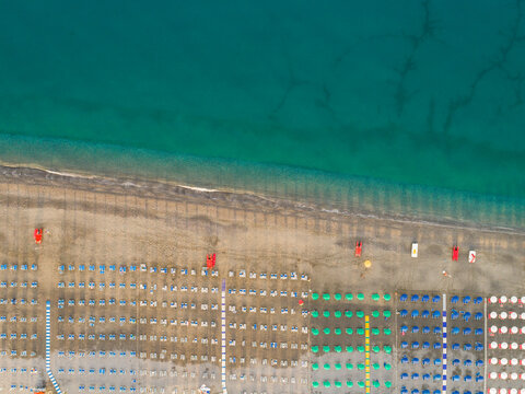Aerial view of the seashore with parasols and sunbeds in Scalea, Calabria, Italy.