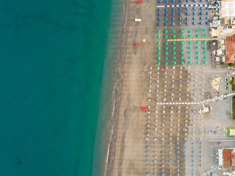 Aerial view of the seashore with parasols and sunbeds in Scalea, Calabria, Italy.