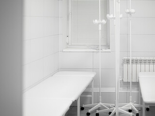 White medical couches for examining and treating a patient in light clean doctor's office. Window...