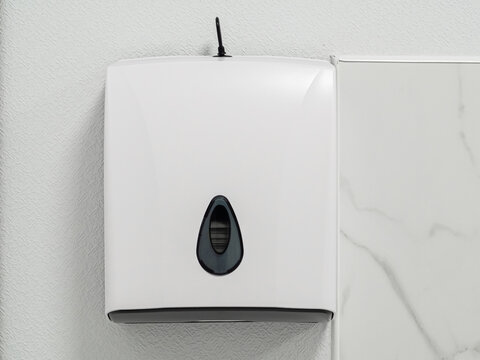 Toilet paper in box sheets for wiping oneself clean after wash face or wash hands and urination on the ceramic wall in modern bathroom