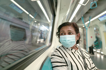 Fototapeta na wymiar Woman commuter wearing face mask inside train