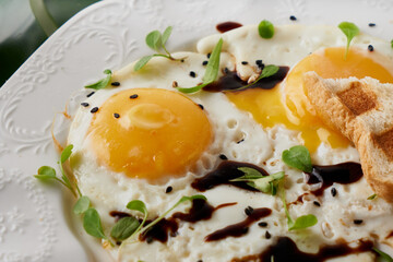 Morning breakfast with fried eggs and plant leaf on white table Closeup