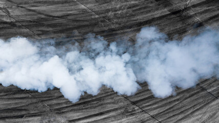 Black tire marks and white smoke on asphalt race track, Road dust cloud from driving car, Combustion fumes of car exhaust pipe, The engine is not working properly. © Kalyakan