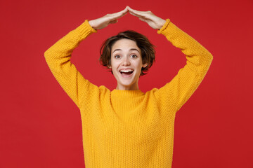Excited cheerful laughing young brunette woman 20s wearing basic casual yellow sweater standing...