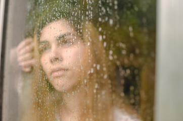 reflection of woman in front of the window on a rainy day