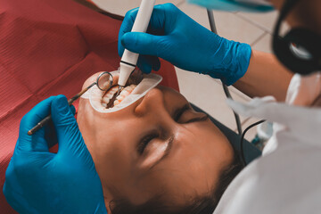 At the dentist's appointment, tartar removal, use of ultrasound, patient and dentist. Retractor for...